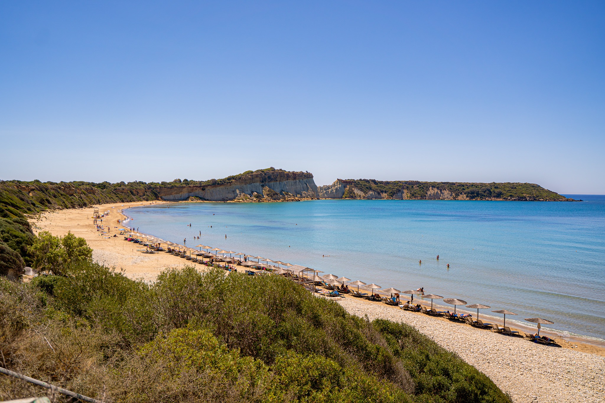 Plaża Gerakas na Zakynthos z leżakami i turkusową wodą Morza Jońskiego, położona na półwyspie Vasilikos