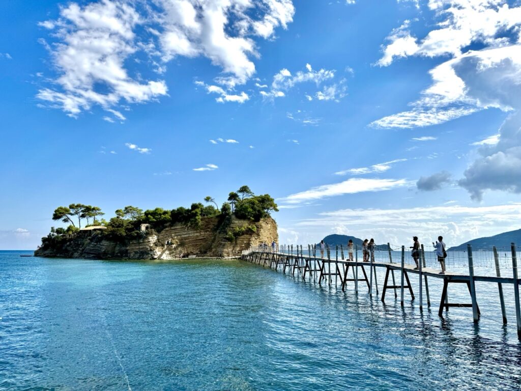 Wyspa Cameo na Zakynthos połączona drewnianym mostem z lądem, widok na turkusowe morze i błękitne niebo