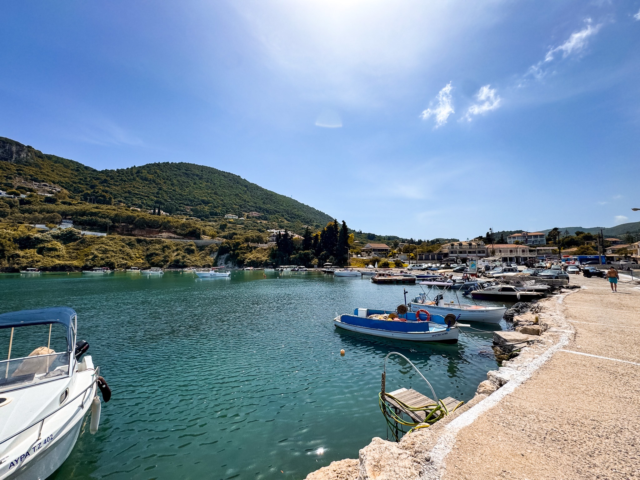 Mały port Keri Limni na Zakynthos z łodziami zacumowanymi przy nabrzeżu i wzgórzami w tle