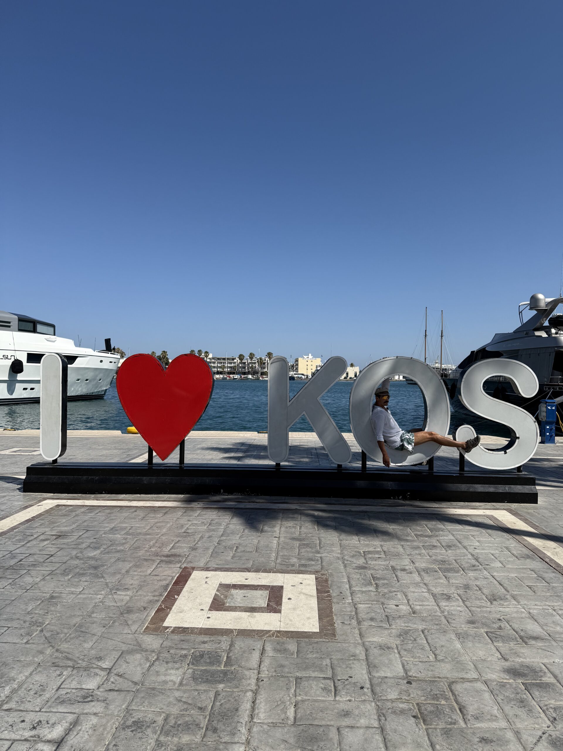 Duży napis I love Kos w porcie z widokiem na morze i jachty