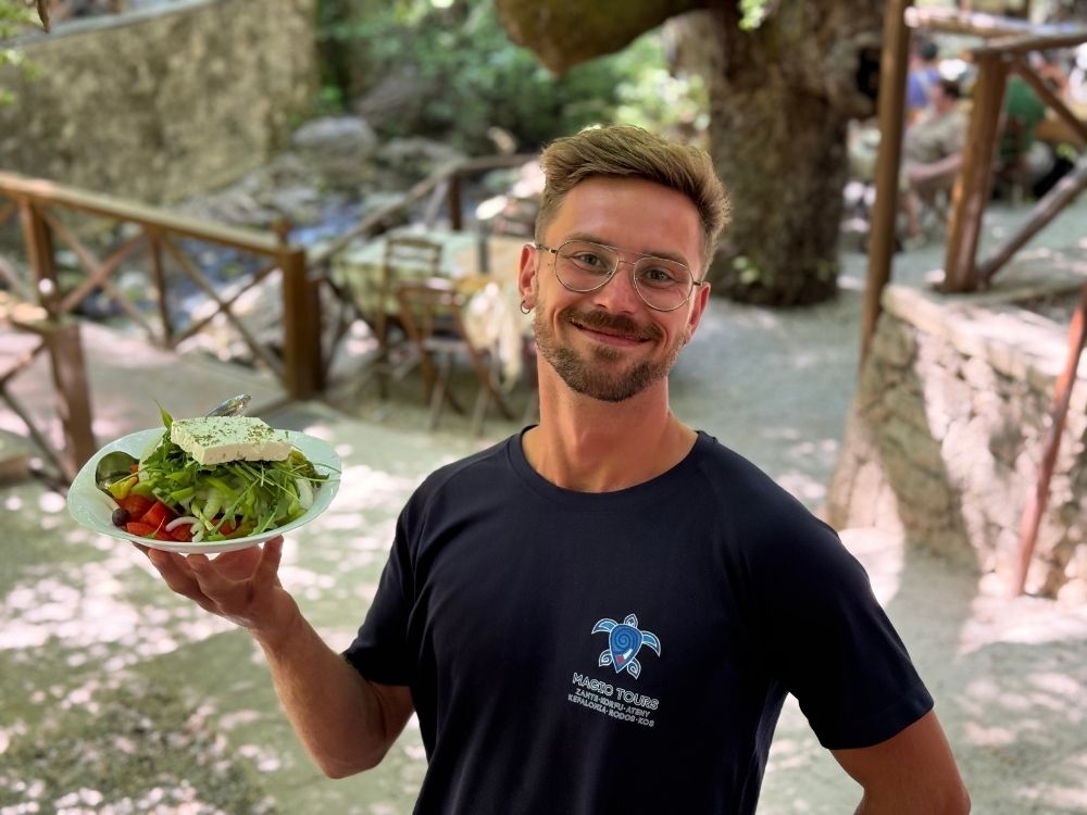 przewodnik trzymający sałatkę grecką w Grecji
